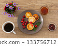 Cup of coffee and curd fritters with raspberries on the wooden background. 133756712