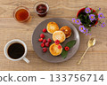 Cup of coffee and curd fritters with raspberries on the wooden background. 133756714
