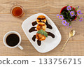 Curd fritters with chocolate and honey. Cup of coffee on the wooden background. 133756715