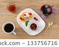 Cup of coffee and curd fritters with sour cream and berries on the porcelain plates. 133756716