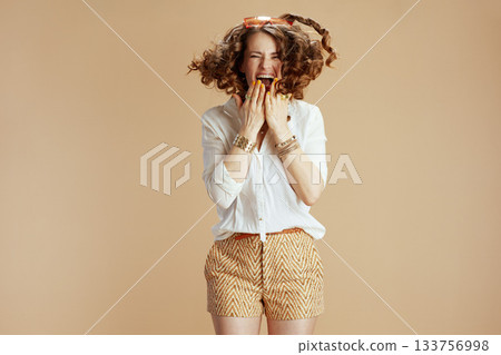 surprised stylish woman in blouse and shorts jumping surprised stylish woman in blouse and shorts jumping 133756998