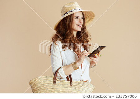 happy trendy woman in blouse and shorts isolated on beige 133757000