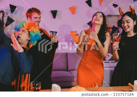 Joyful office Halloween party with coworkers in costumes, celebrating with drinks and laughter, fostering teamwork and festive spirit 133757184