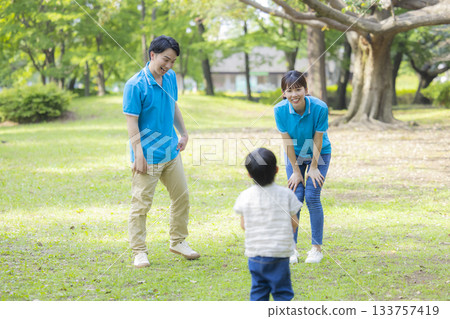 Male and female staff in blue polo shirts playing with children 133757419