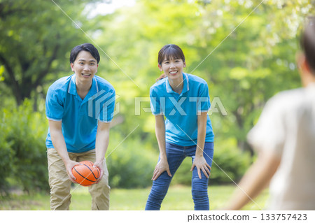 Male and female staff in blue polo shirts playing with children 133757423