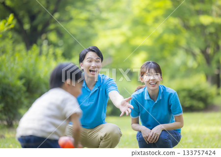 Male and female staff in blue polo shirts playing with children 133757424