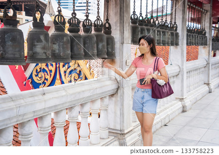 Woman Touching Temple Bells 133758223