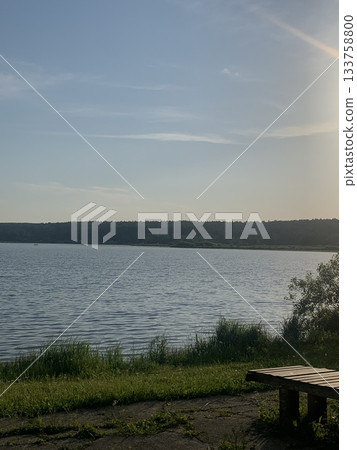 peaceful sunset by tranquil waters, quiet evening scene with reflective lake surface 133758800