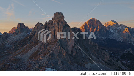 Panoramic view of Dolomite mountain peaks in beautiful morning light. Early winter scene with snow covered summits. 133758966