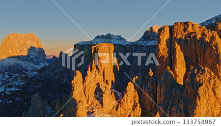 Panoramic view of Dolomite mountain peaks in beautiful morning light. Early winter scene with snow covered summits. 133758967
