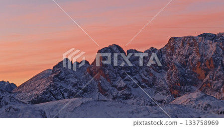 Panoramic view of Dolomite mountain peaks in beautiful morning light. Early winter scene with snow covered summits. Panoramic view of Dolomite mountain peaks in beautiful morning light. Early winter scene with snow covered summits. 133758969