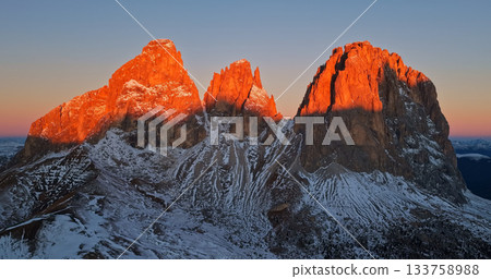 Panoramic view of Dolomite mountain peaks in beautiful morning light. Early winter scene with snow covered summits. Panoramic view of Dolomite mountain peaks in beautiful morning light. Early winter scene with snow covered summits. 133758988