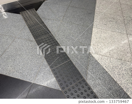 Tactile tiles for people with disabilities. Floor mounted navigation guides for visually impaired people. Raised panels with dots for indicating route using steps 133759467