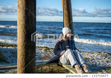 woman enjoying windy winter day on baltic sea coast 133759477