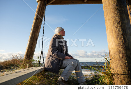 woman enjoying windy winter day on baltic sea coast 133759478