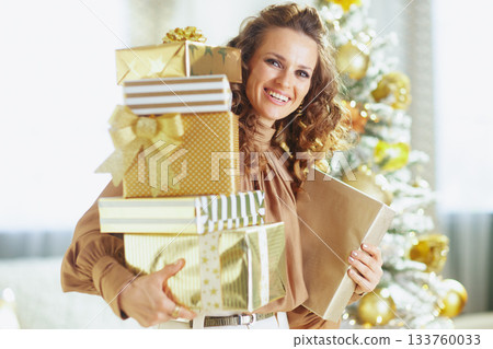 Cheerful Woman with Golden Christmas Gifts Cheerful Woman with Golden Christmas Gifts 133760033