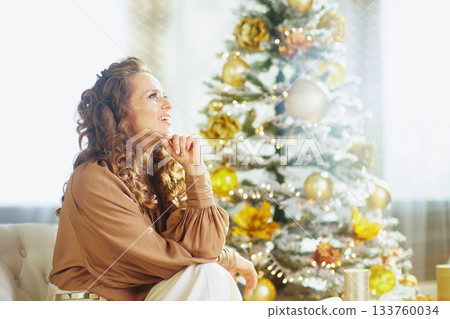 Relaxed Woman by a Golden Holiday Tree Relaxed Woman by a Golden Holiday Tree 133760034