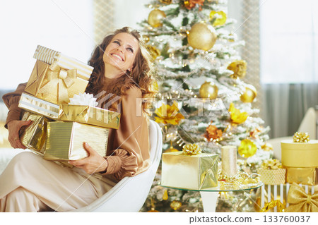 Smiling Woman with Gold Striped Christmas Gifts 133760037