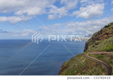 Rainbow over Atlantic near Garajau cliffs Madeira with coastal road and sunlit Funchal buildings 133760419