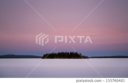 winter island on frozen lake under pastel pink sunset sky in Finnish lapland winter island on frozen lake under pastel pink sunset sky in Finnish lapland 133760481
