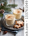 Eggnog Christmas milk cocktail with cinnamon, served in two glasses on vintage tray with shortbread star shape sugar cookies 133761049