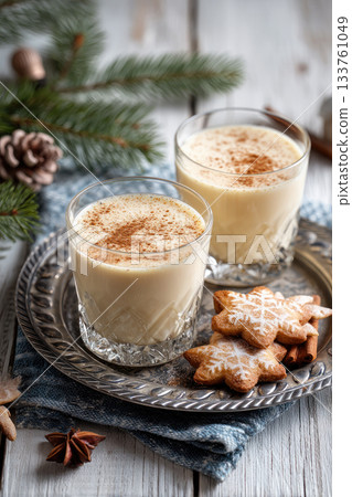 Eggnog Christmas milk cocktail with cinnamon, served in two glasses on vintage tray with shortbread star shape sugar cookies Eggnog Christmas milk cocktail with cinnamon, served in two glasses on vintage tray with shortbread star shape sugar cookies 133761049