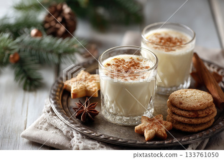 Eggnog Christmas milk cocktail with cinnamon, served in two glasses on vintage tray with shortbread star shape sugar cookies 133761050