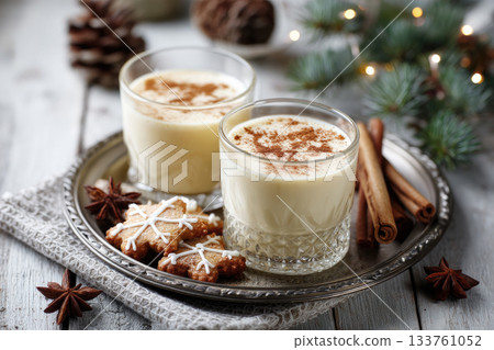 Eggnog Christmas milk cocktail with cinnamon, served in two glasses on vintage tray with shortbread star shape sugar cookies Eggnog Christmas milk cocktail with cinnamon, served in two glasses on vintage tray with shortbread star shape sugar cookies 133761052