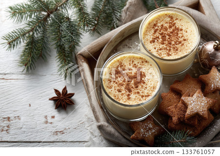Eggnog Christmas milk cocktail with cinnamon, served in two glasses on vintage tray with shortbread star shape sugar cookies 133761057