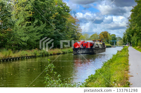 Peaceful waterway lined with trees and lulled by calm breeze 133761298