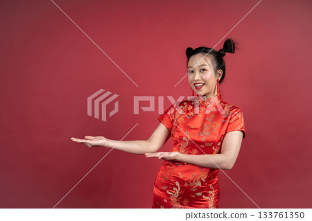 Friendly Chinese female gesturing to side for Lunar New Year advertisement Friendly Chinese female gesturing to side for Lunar New Year advertisement 133761350