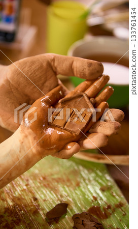 Father holding daughter hand with clay house sculpture Father holding daughter hand with clay house sculpture 133761454