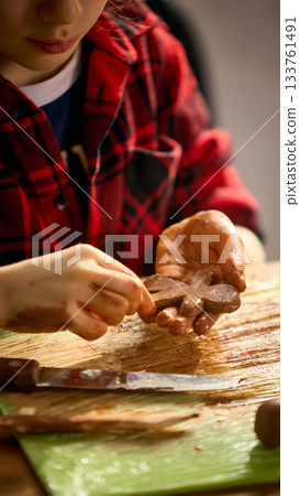 Girl sculpting clay gingerbread figure with focus Girl sculpting clay gingerbread figure with focus 133761491