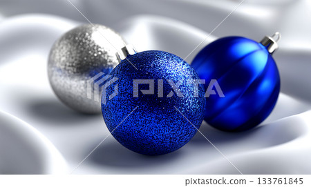 Sparkling blue and elegant silver Christmas ornaments shimmer on soft white satin, evoking festive joy and luxury holiday celebrations. Sparkling blue and elegant silver Christmas ornaments shimmer on soft white satin, evoking festive joy and luxury holiday celebrations. 133761845