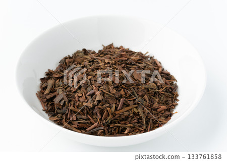 白色背景上的碟子裡的焙茶茶葉 白色背景上的碟子裡的焙茶茶葉 133761858
