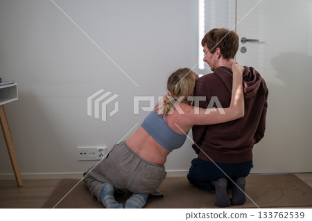 couple doing partner stretching exercise together at home on yoga mats 133762539