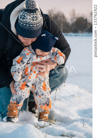 Father and Baby Enjoying Snowy Day Together 133762922