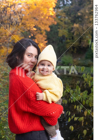 Mother and Baby Smiling in Autumn Park Mother and Baby Smiling in Autumn Park 133762964