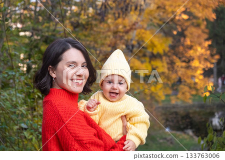 Mother and Baby Smiling in Autumn Park Mother and Baby Smiling in Autumn Park 133763006