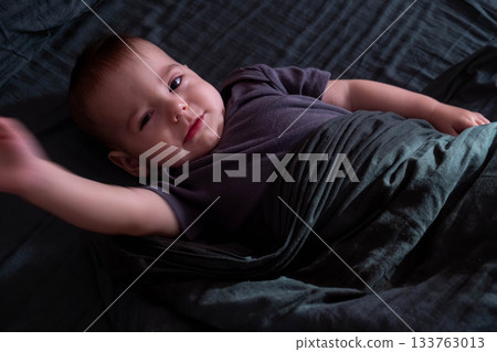 Baby Waving in Bed with Dark Blanket Baby Waving in Bed with Dark Blanket 133763013
