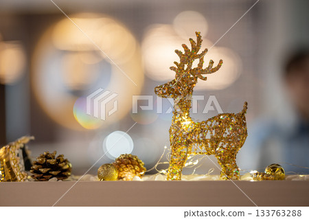 A decorative golden glitter reindeer figurine 133763288
