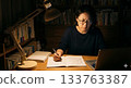 一位四十多歲的女性晚上在書房裡用電腦做筆記。一位中年日本男性正在努力提陞技能和獲得資格證書。 133763387