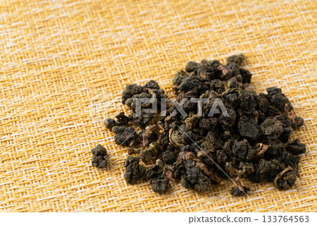 Dongding oolong tea leaves placed on a yellow cloth Dongding oolong tea leaves placed on a yellow cloth 133764563