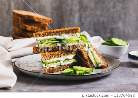 Cucumber sandwich with butter and cream cheese on a plate on the table Cucumber sandwich with butter and cream cheese on a plate on the table 133764588