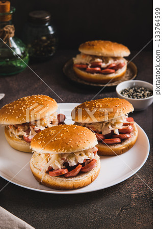 Burgers with grilled sausage and coleslaw on a plate vertical view Burgers with grilled sausage and coleslaw on a plate vertical view 133764599