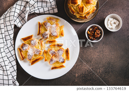 Sweet puff pastries with pineapple in powdered sugar on the table top view Sweet puff pastries with pineapple in powdered sugar on the table top view 133764619