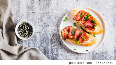 Baked bruschetta with ricotta and bacon on a plate on the table top view web banner Baked bruschetta with ricotta and bacon on a plate on the table top view web banner 133764630