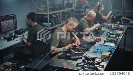 Engineers Collaborating on FPV Drone Production in Modern Workshop Engineers Collaborating on FPV Drone Production in Modern Workshop 133764946