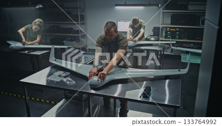 Woman and Men Assembling Advanced Military Drones in Factory Woman and Men Assembling Advanced Military Drones in Factory 133764992