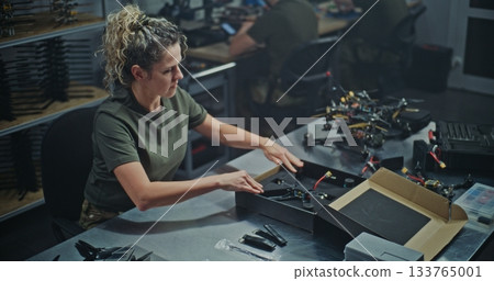 Female Engineer Assembling FPV Drone For Defense or Security Purposes 133765001